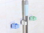 Porte-brosse auto-adhésif pour mop à manche