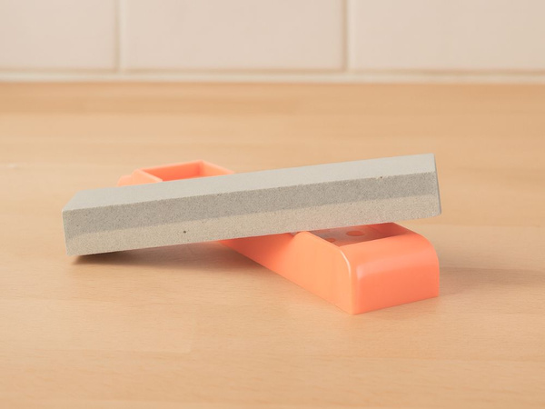 Stone sharpener for knives and scissors, double-sided, rectangular, on a base